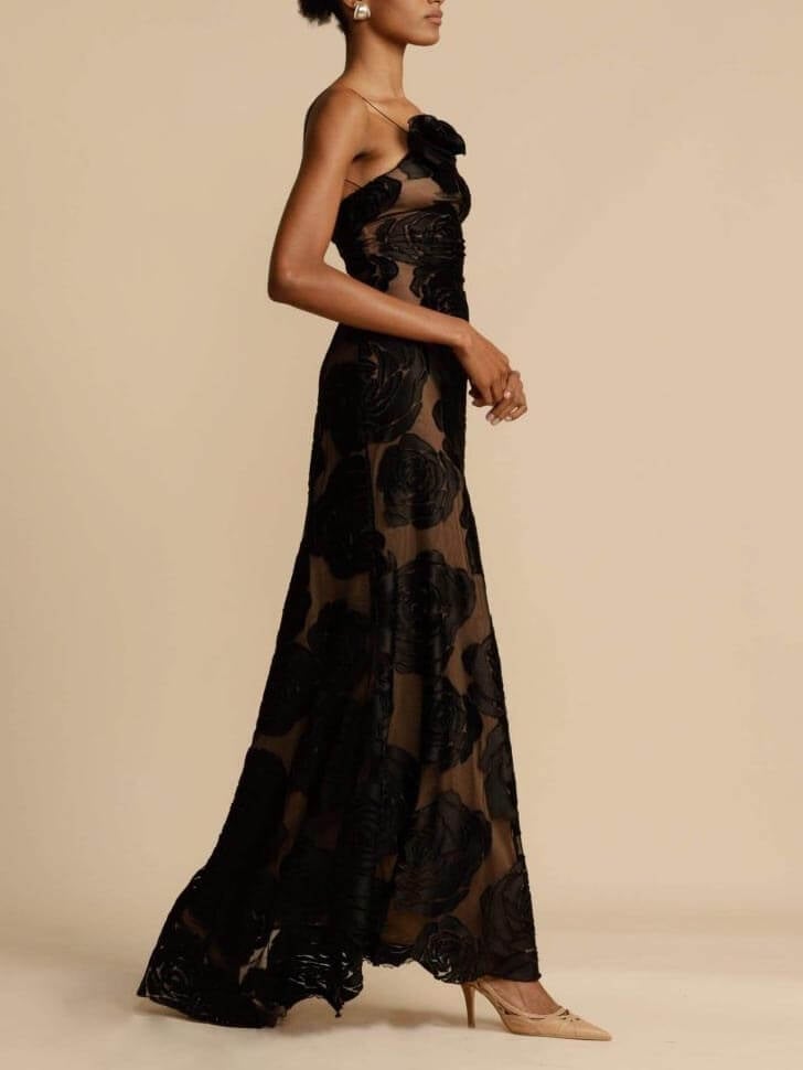 Side view of woman in the Arabella black floral maxi dress highlighting the elongated flowing cut