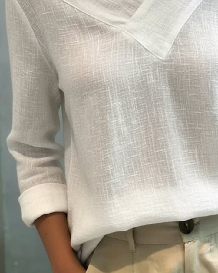 Aria long sleeve top in white showing asymmetric neckline and flowing relaxed fit, side view
