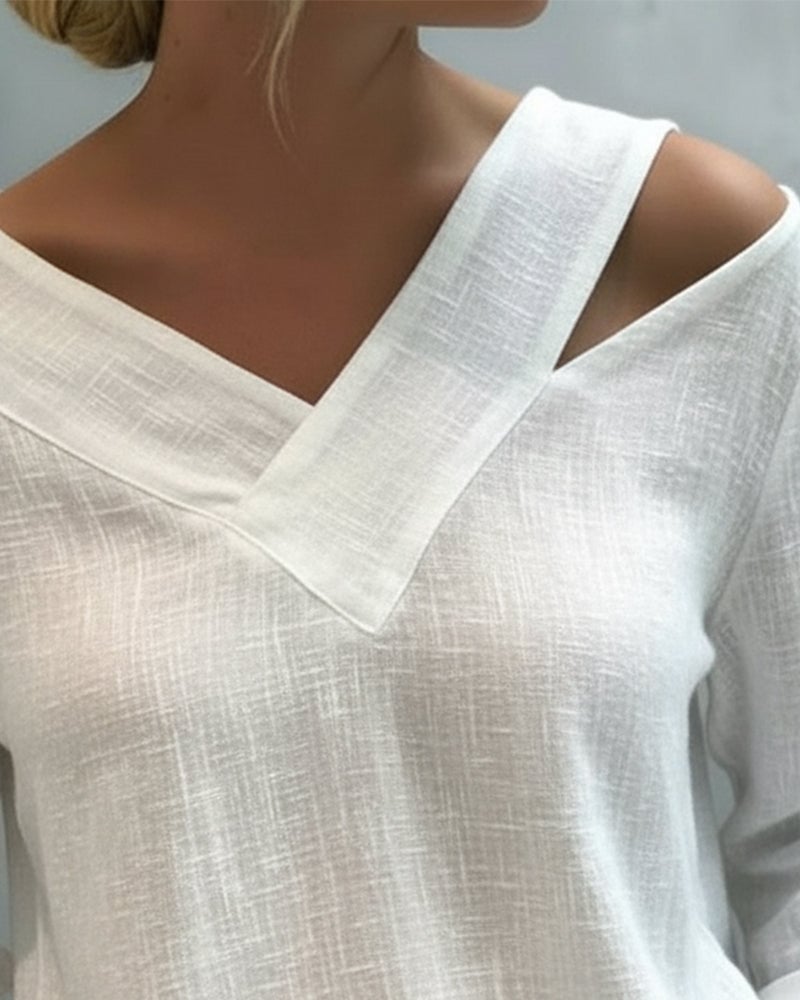Close-up of asymmetric V-neckline and single wide shoulder strap on white Aria top