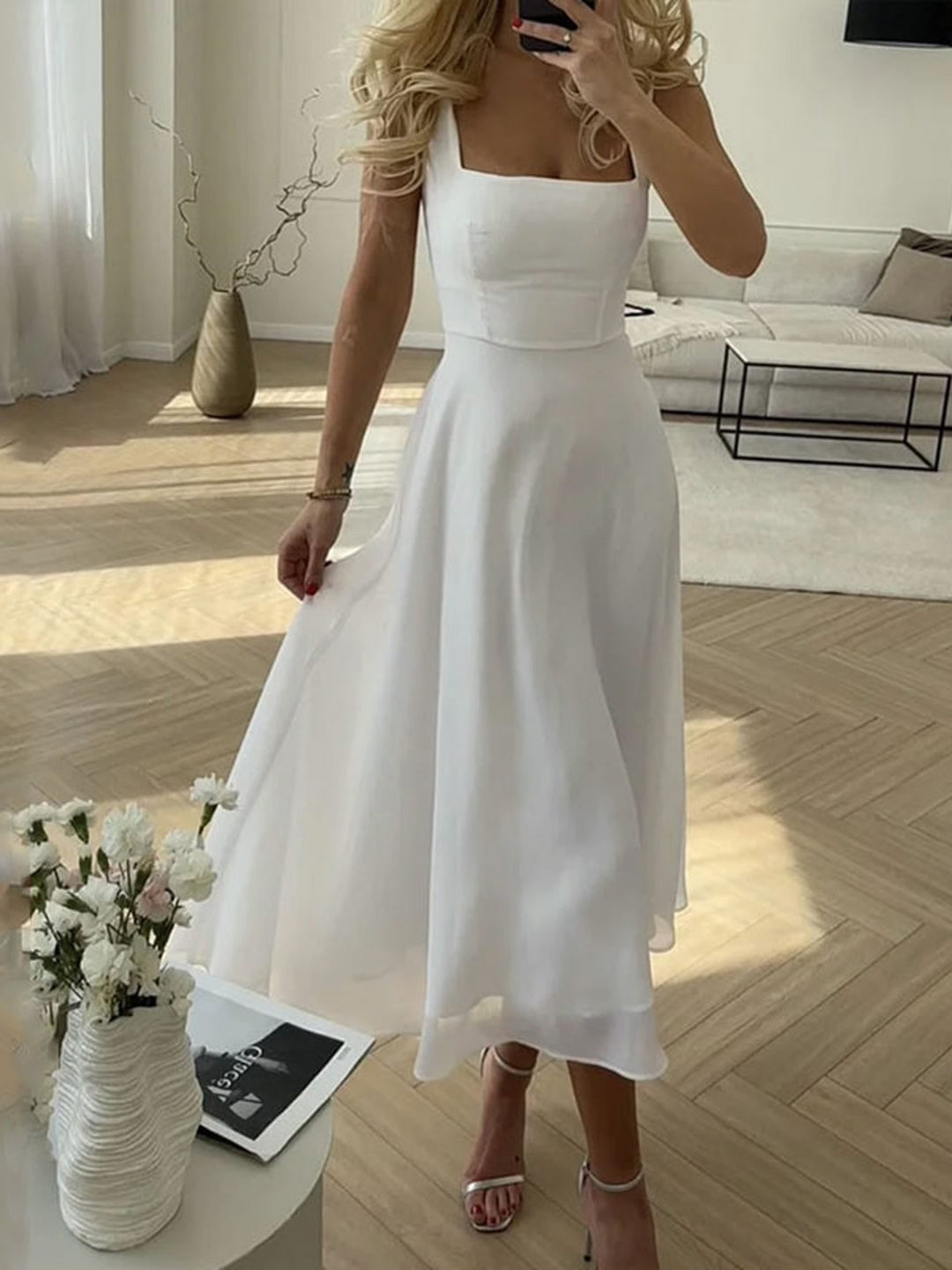 Woman wearing the Aria white square neck A-line midi dress with a fitted bodice and flowing skirt, front view
