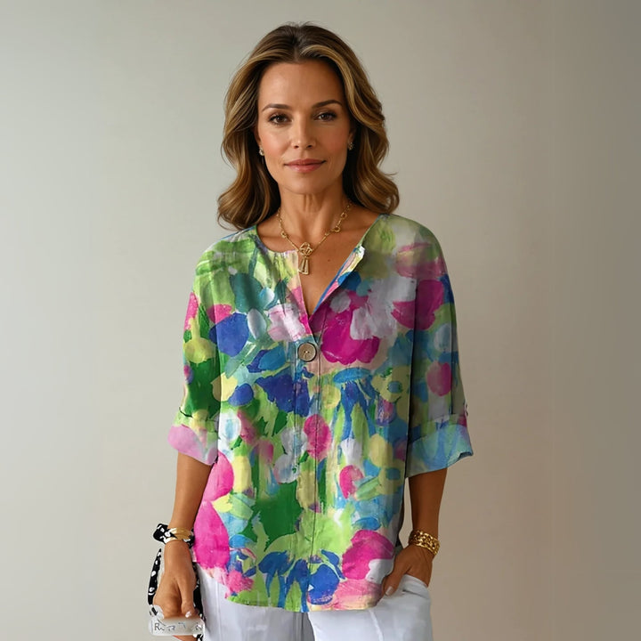 Model in the Arlene floral blouse in green colorway, paired with casual denim jeans