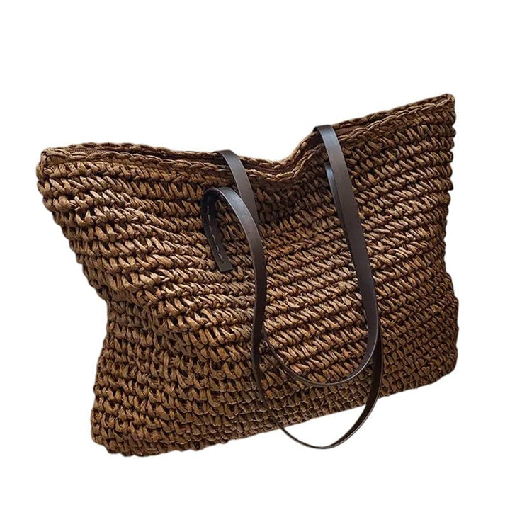 Flat lay of the beach tote bag styled with summer accessories on a sandy surface