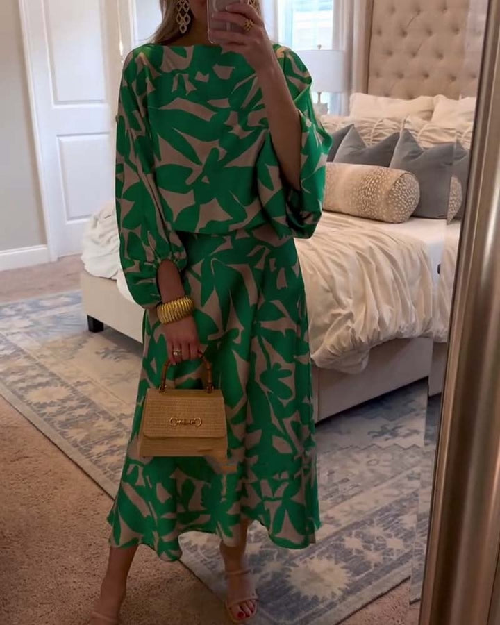 Model wearing a green two-piece printed lantern sleeve top and skirt set, front view
