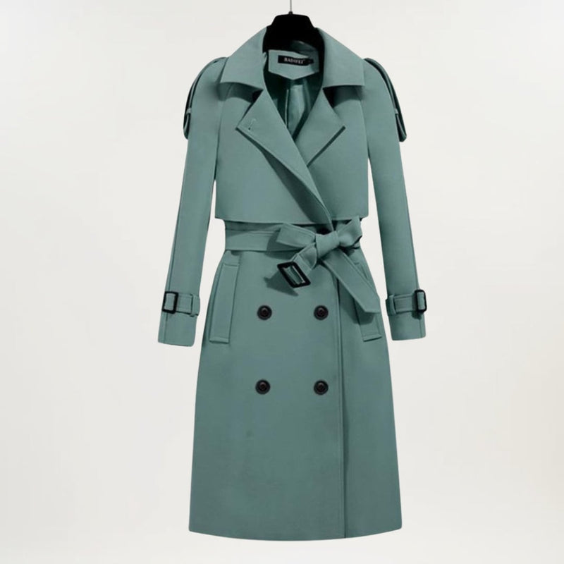 Woman wearing a longline trench coat in a neutral tone, styled with the belt cinched at the waist