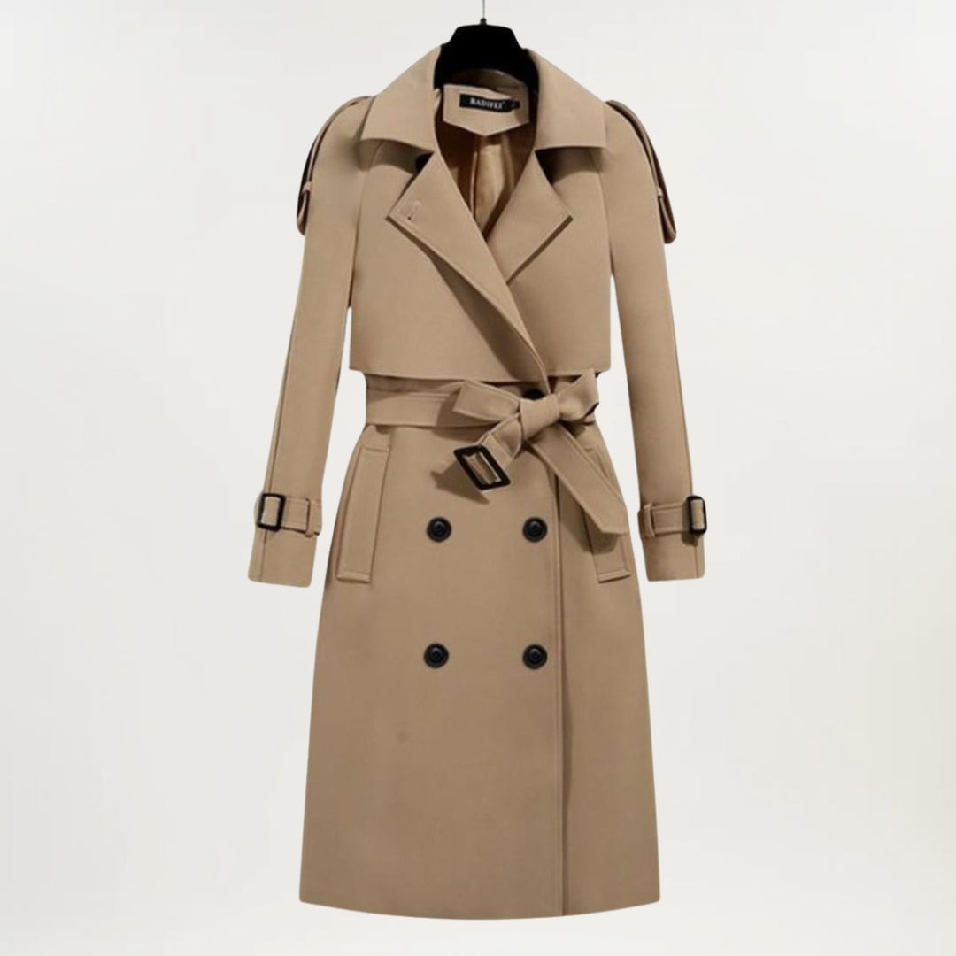 Model in a black longline trench coat with deep pockets and adjustable belt, front-facing pose