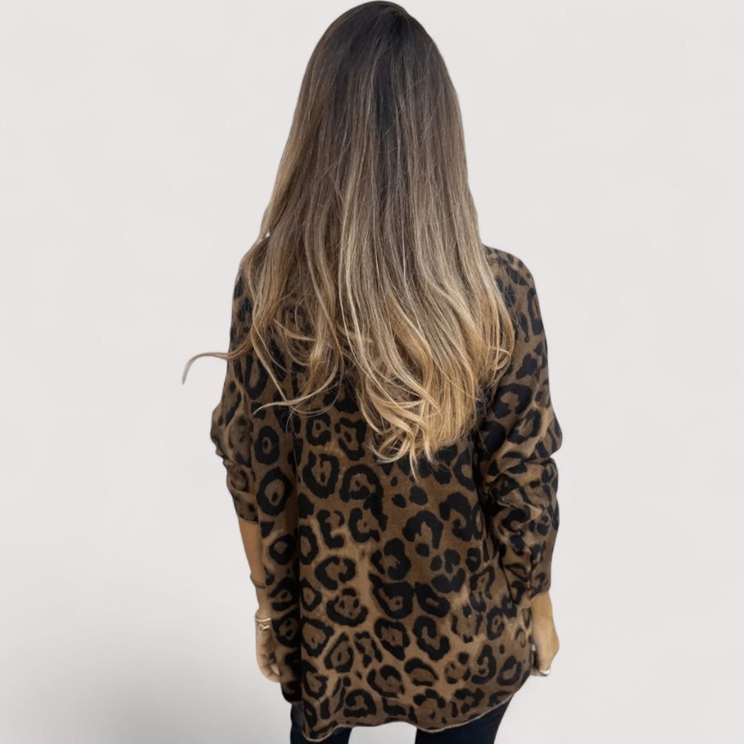 Model posing in a white leopard print top paired with jeans