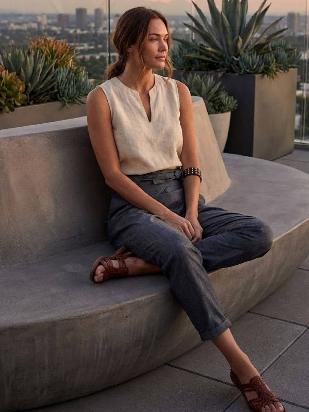 Close-up of self-tie bow detail on high waistband of gray cropped pants