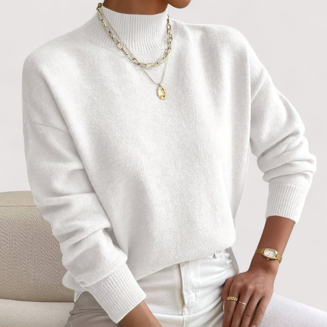 Woman wearing a soft white turtleneck sweater with a smooth, flattering fit
