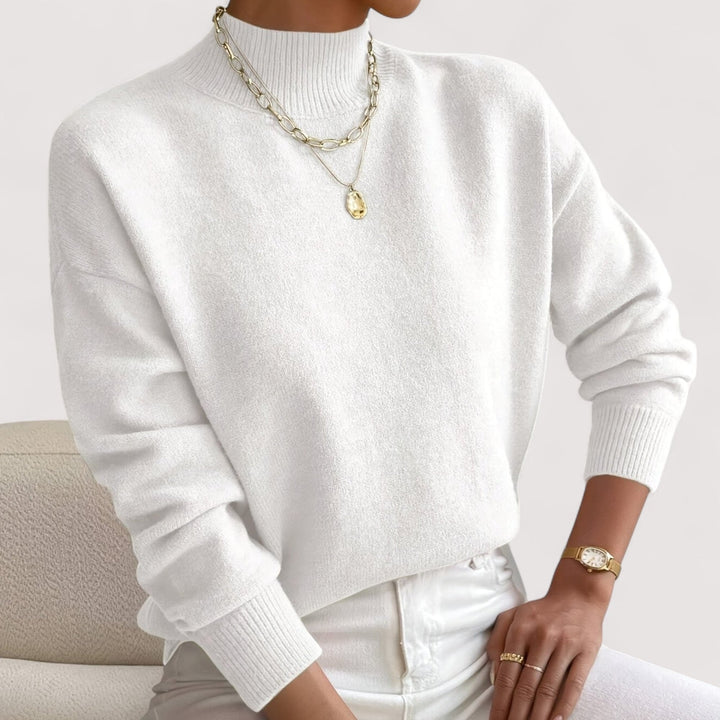Woman wearing a soft white turtleneck sweater with a smooth, flattering fit