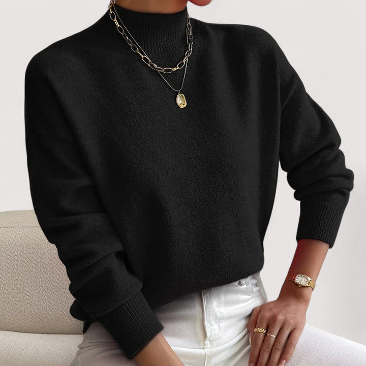 Woman wearing a black turtleneck sweater paired with tailored trousers