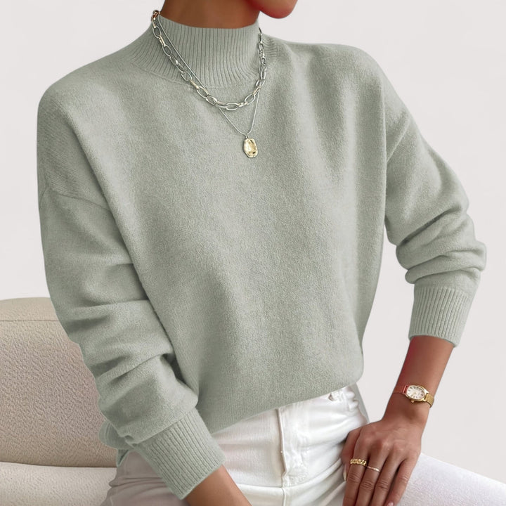 Overhead flatlay of multiple turtleneck sweater color options including white, beige, and black