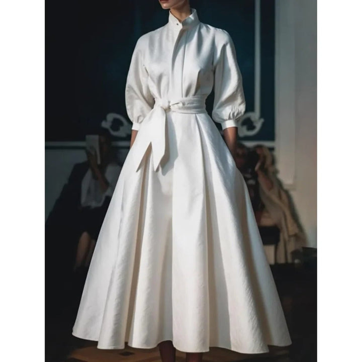 Close-up of the tailored shirt collar and belted waist detail on a white A-line midi dress