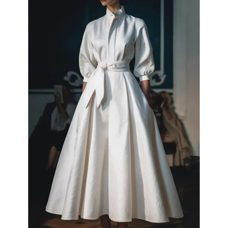Close-up of the tailored shirt collar and belted waist detail on a white A-line midi dress