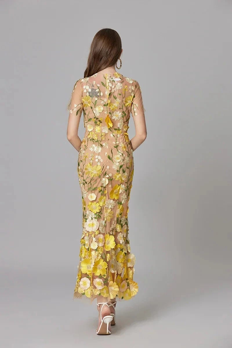 Detail shot of the crew neckline and floral appliqués on the Aurelia sheer maxi dress
