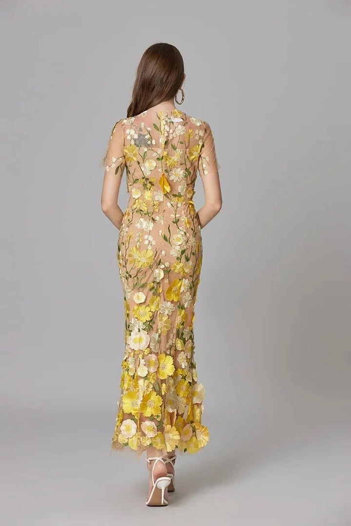 Detail shot of the crew neckline and floral appliqués on the Aurelia sheer maxi dress