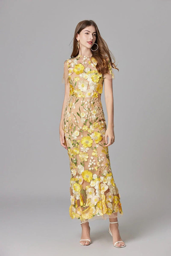 Flat lay of the Aurelia sheer mesh maxi dress showing floral appliqué detail across the silhouette