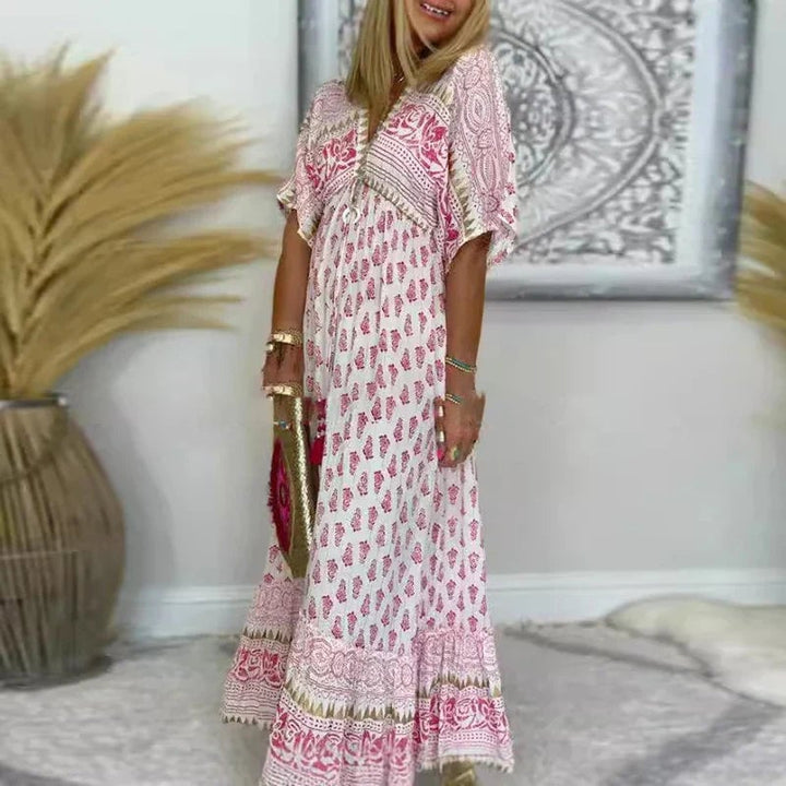 Woman wearing a pink boho print maxi dress with a flowing silhouette, styled for a warm-weather casual look