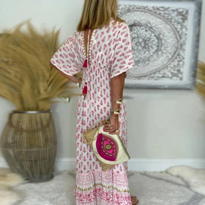 Full-length view of a pink boho maxi dress on a model, highlighting the floor-grazing length and relaxed fit