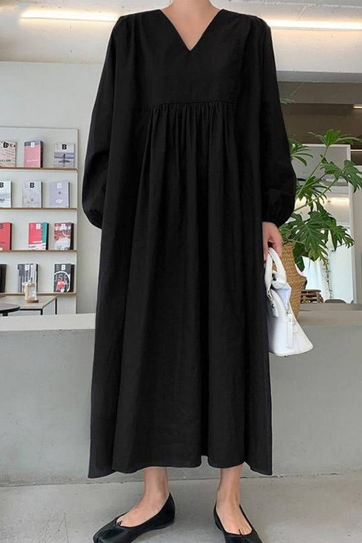 Side profile of black balloon sleeve midi dress showing silhouette and midi length