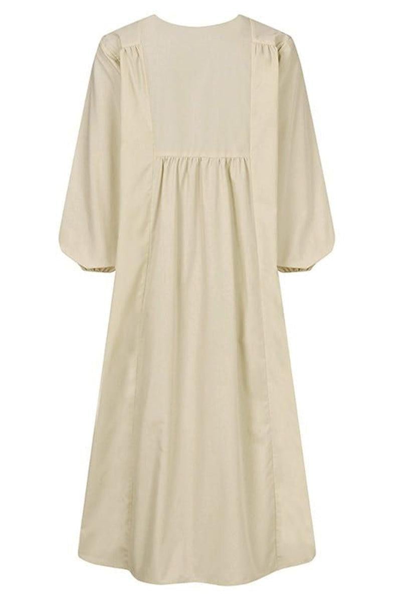 Close-up of gathered v-neckline and balloon sleeve cuff detail on white midi dress