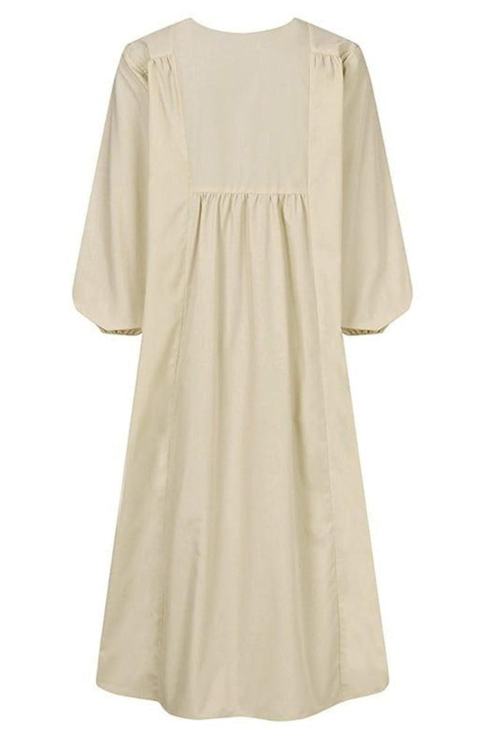 Close-up of gathered v-neckline and balloon sleeve cuff detail on white midi dress