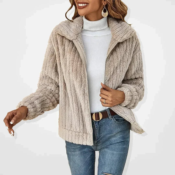 Woman wearing the Ava elegant plush jacket in a soft apricot color, front view showing flattering silhouette