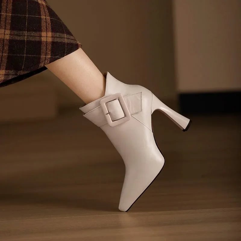 Aveline buckle heel boots in beige with bold buckle accents and contoured heel, front view