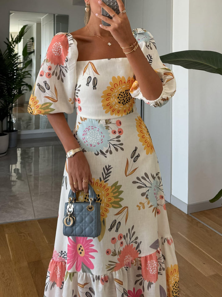 Close-up of the layered ruffled hem on a floral puff sleeve midi dress