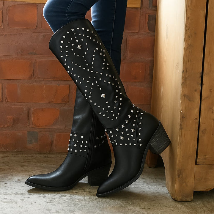 Model wearing Axela western knee-high boots in purple styled with jeans