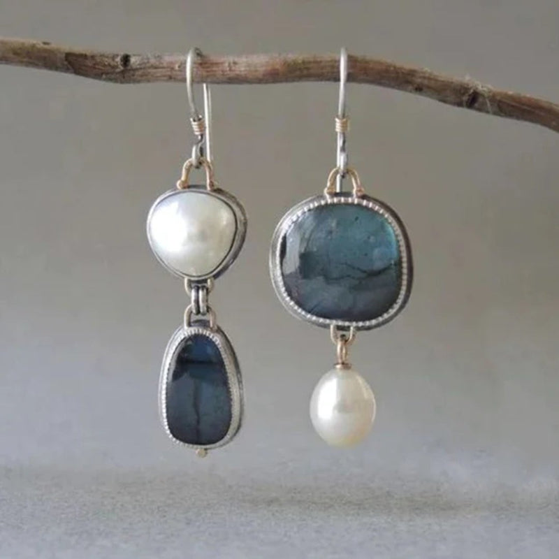 Vintage blue gem and pearl drop earrings with elegant detailing on a neutral background