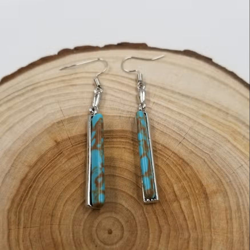 Vintage turquoise drop earrings shown from a side angle highlighting their length and design