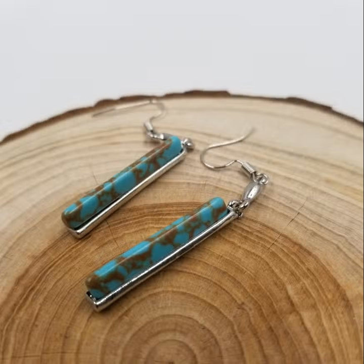 Model wearing vintage turquoise drop earrings styled with a casual boho outfit