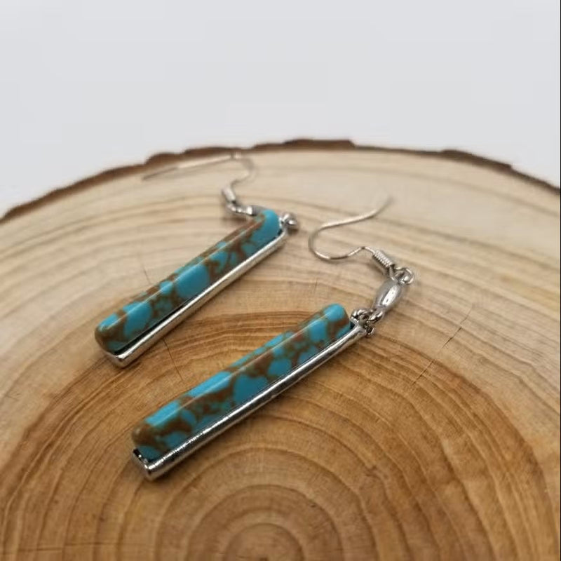 Model wearing vintage turquoise drop earrings styled with a casual boho outfit