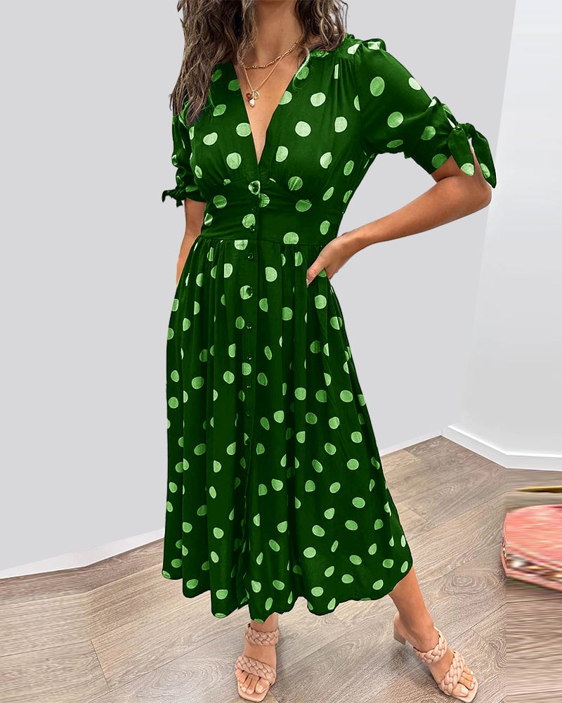 Front view of elegant polka dot dress showing V-neckline and button detail
