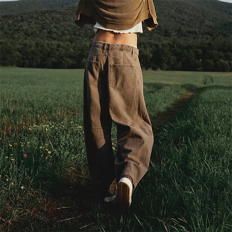 Model wearing light blue barrel leg jeans with a white crop top