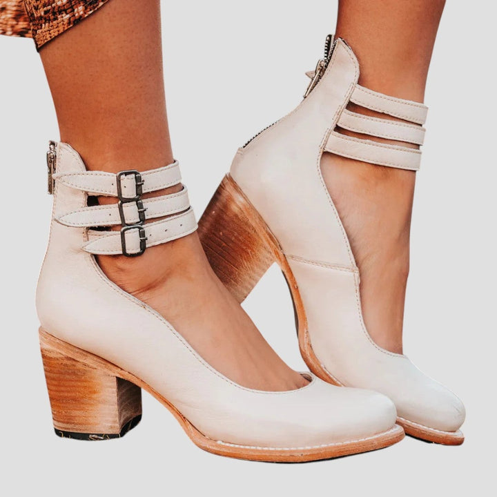 Women's boots in cream color styled with casual outfit on neutral background