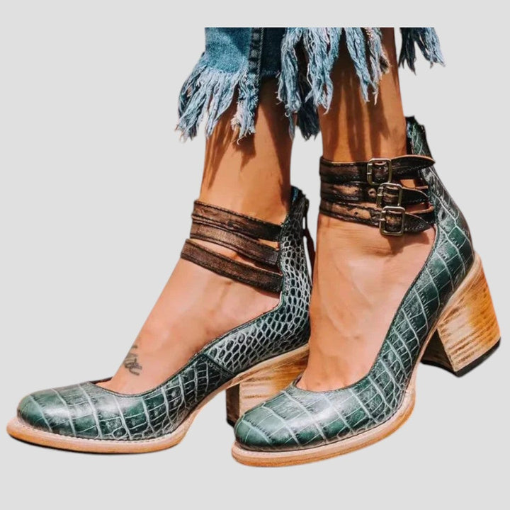 Green snake print boots with mid-calf cut photographed on minimalist background