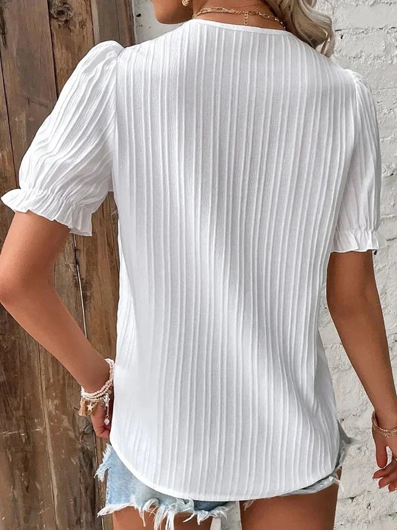 Front view of the Bea lace blouse showing subtle pleated puff sleeves and refined lace finishing detail
