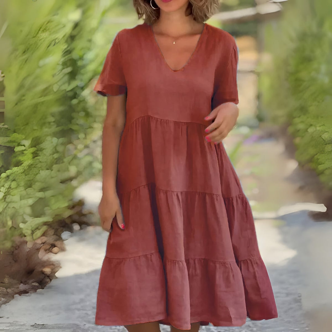 Full-length shot of the Beatrice V-neck flowy dress in brown styled for a casual daytime look
