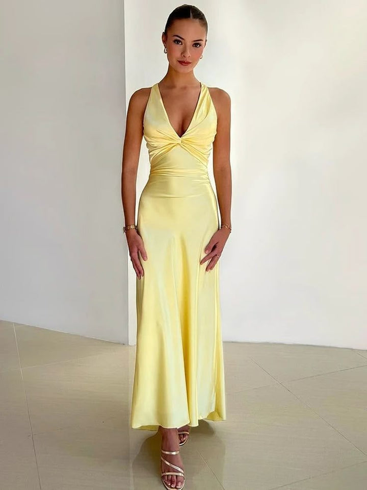 Woman wearing a yellow V-neck maxi dress with a romantic bow-back detail and flowing full-length silhouette
