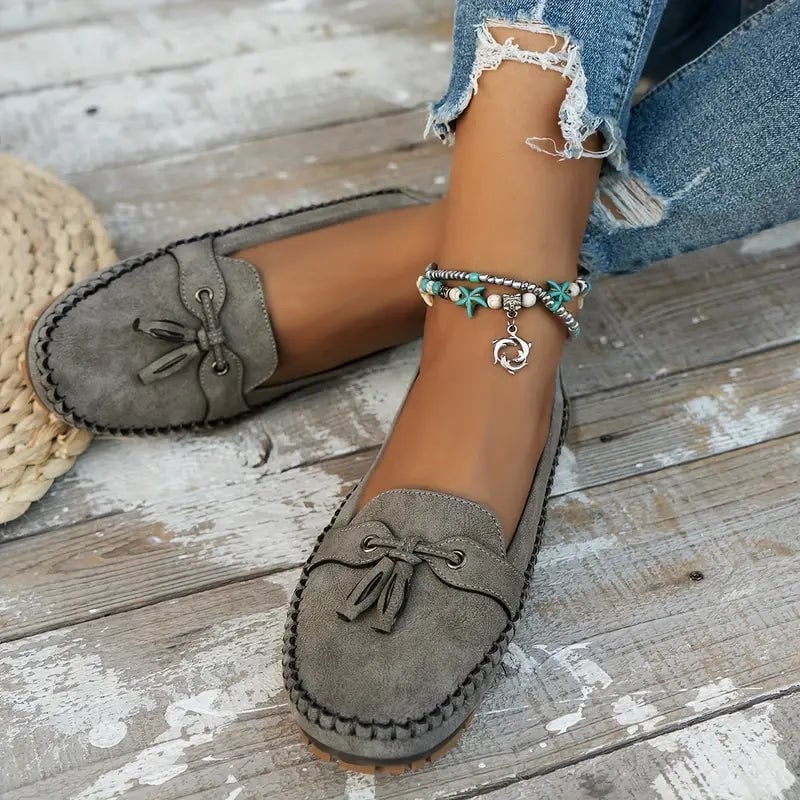 Side profile of women's vintage-style bow loafers in gray showing ergonomic sole