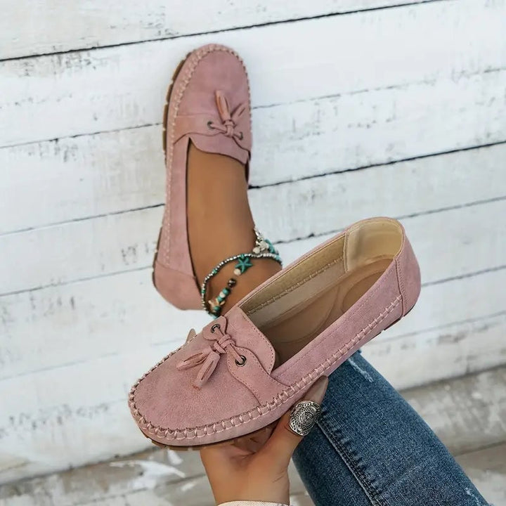 Top-down view of pink bow loafers highlighting polished finish and bow embellishment