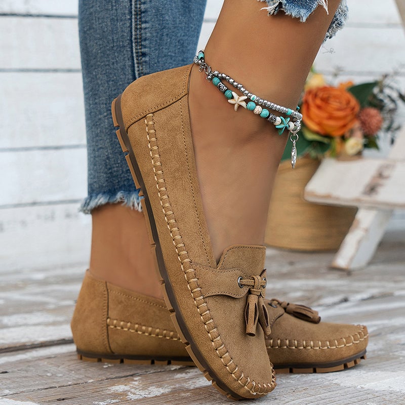 Brown vintage-style bow loafers for women on a neutral background