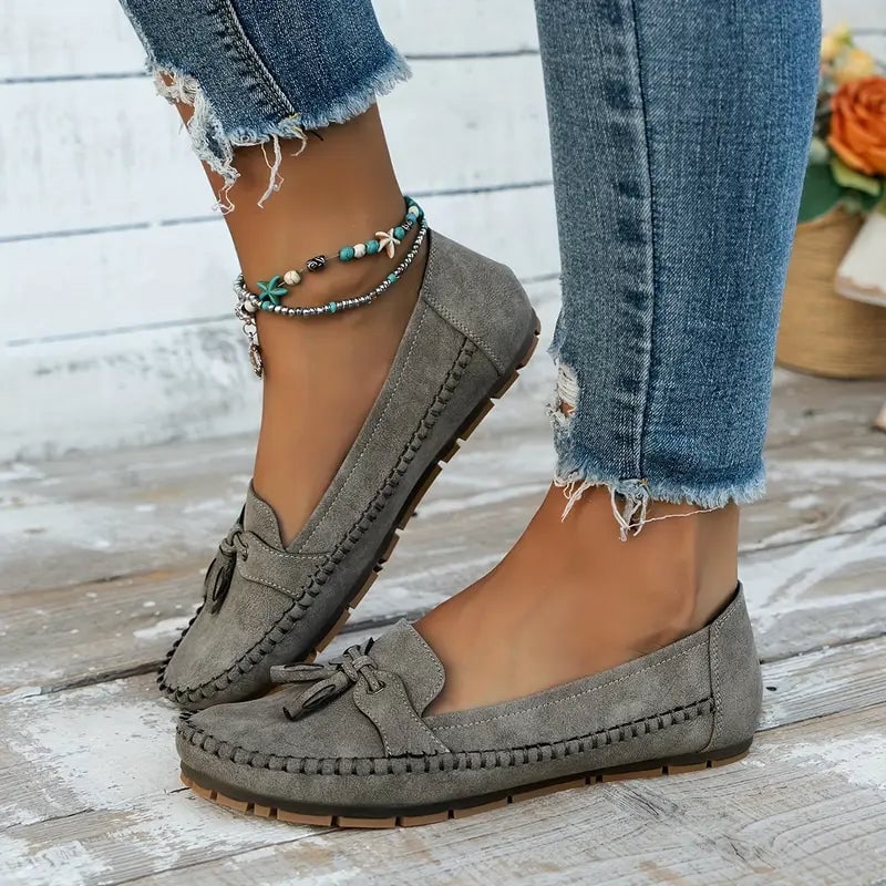 Women's blue bow loafers shown from the heel angle