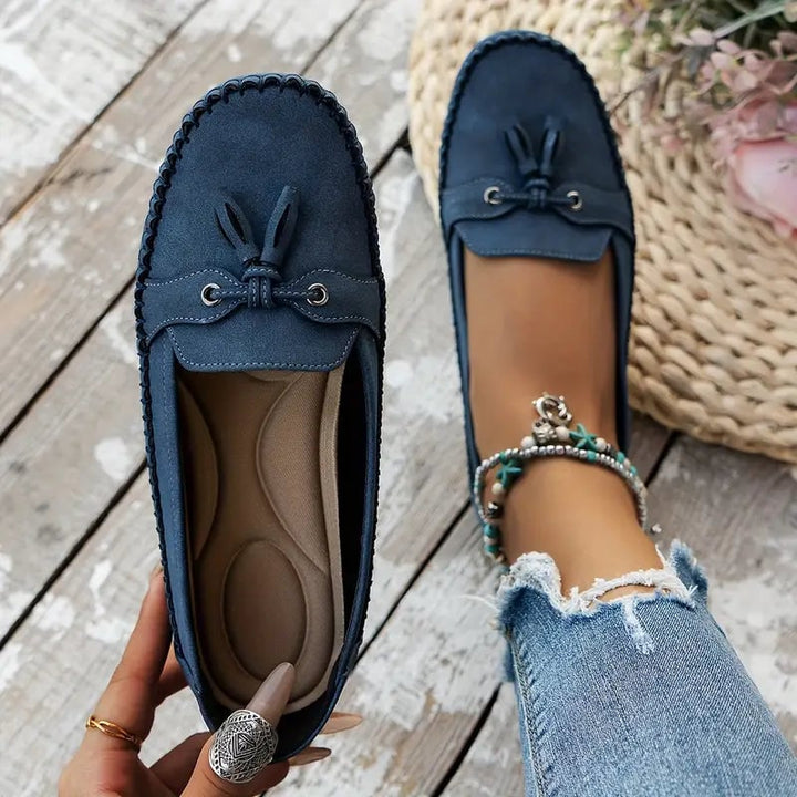 Brown comfort loafers shown in a flat lay styling shot