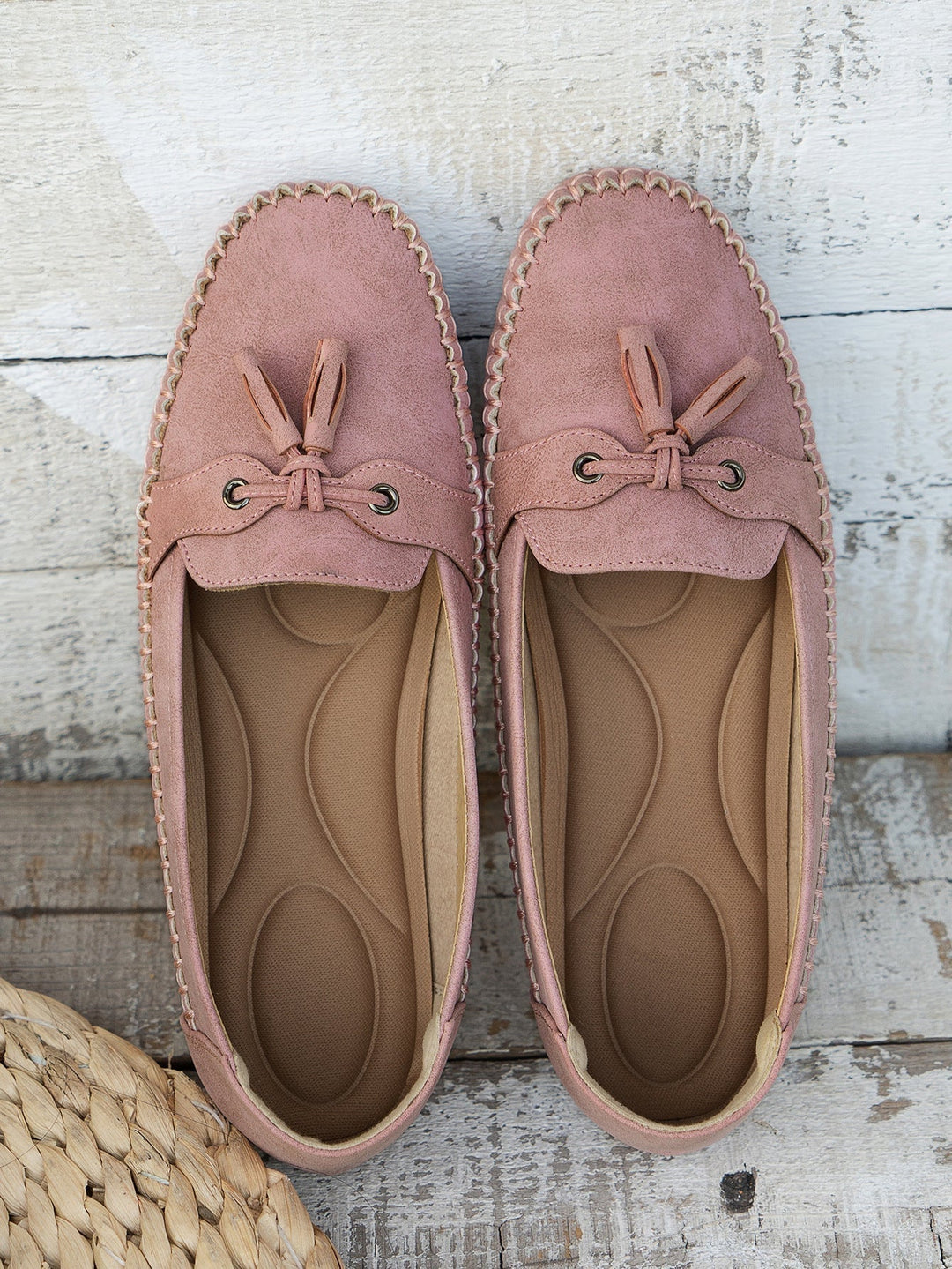 Side view of gray loafers showing flexible material and bow accent