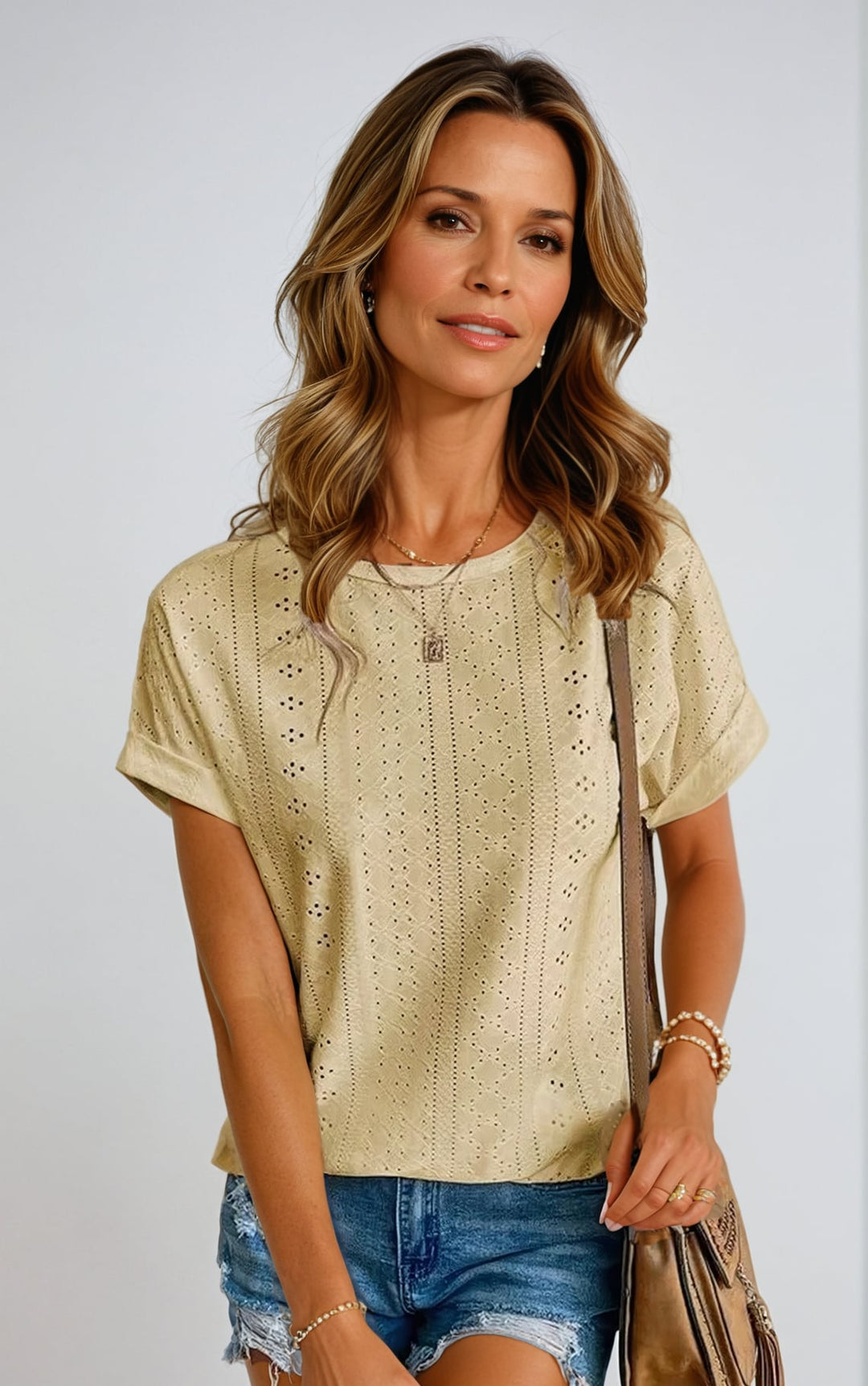 Side view of a woman modeling a green eyelet blouse with a loose, airy silhouette