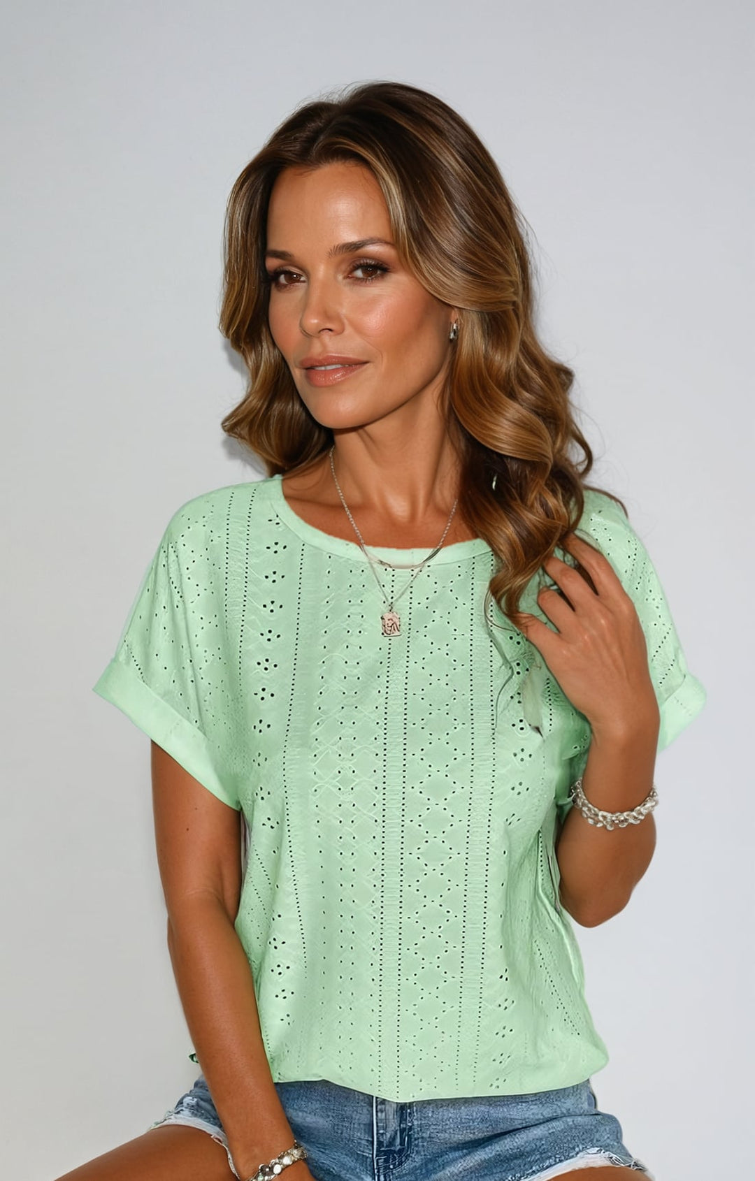 Detail shot of the eyelet fabric texture on a women's casual summer top in yellow
