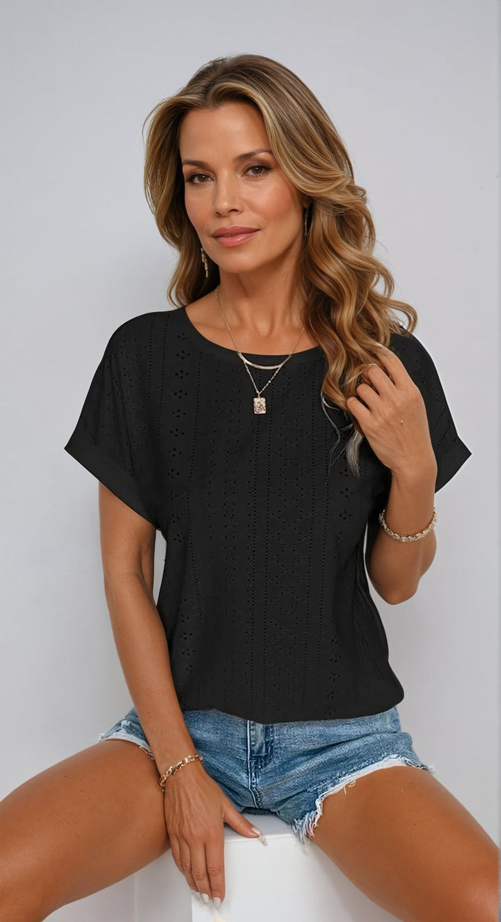Woman wearing a black eyelet top with relaxed fit, shown from the front