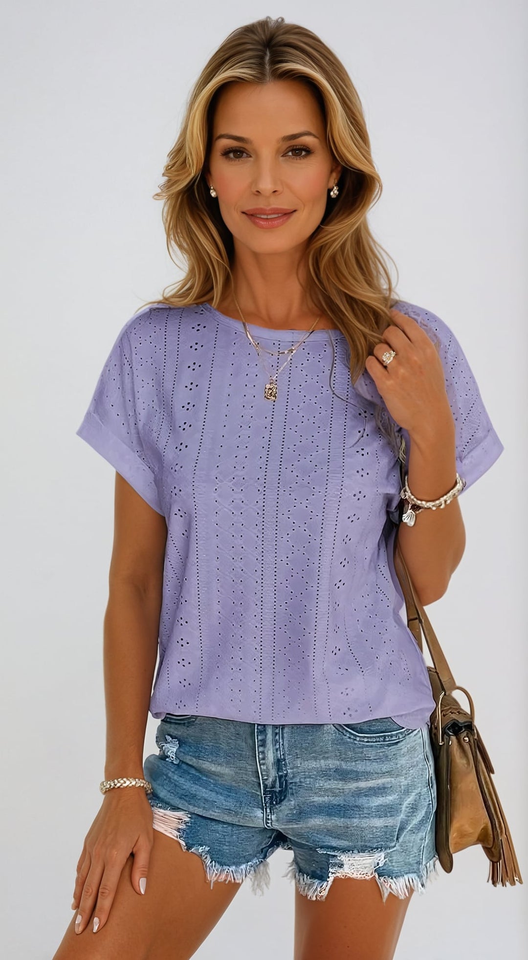 Woman styling a light brown eyelet blouse with denim shorts for a casual look